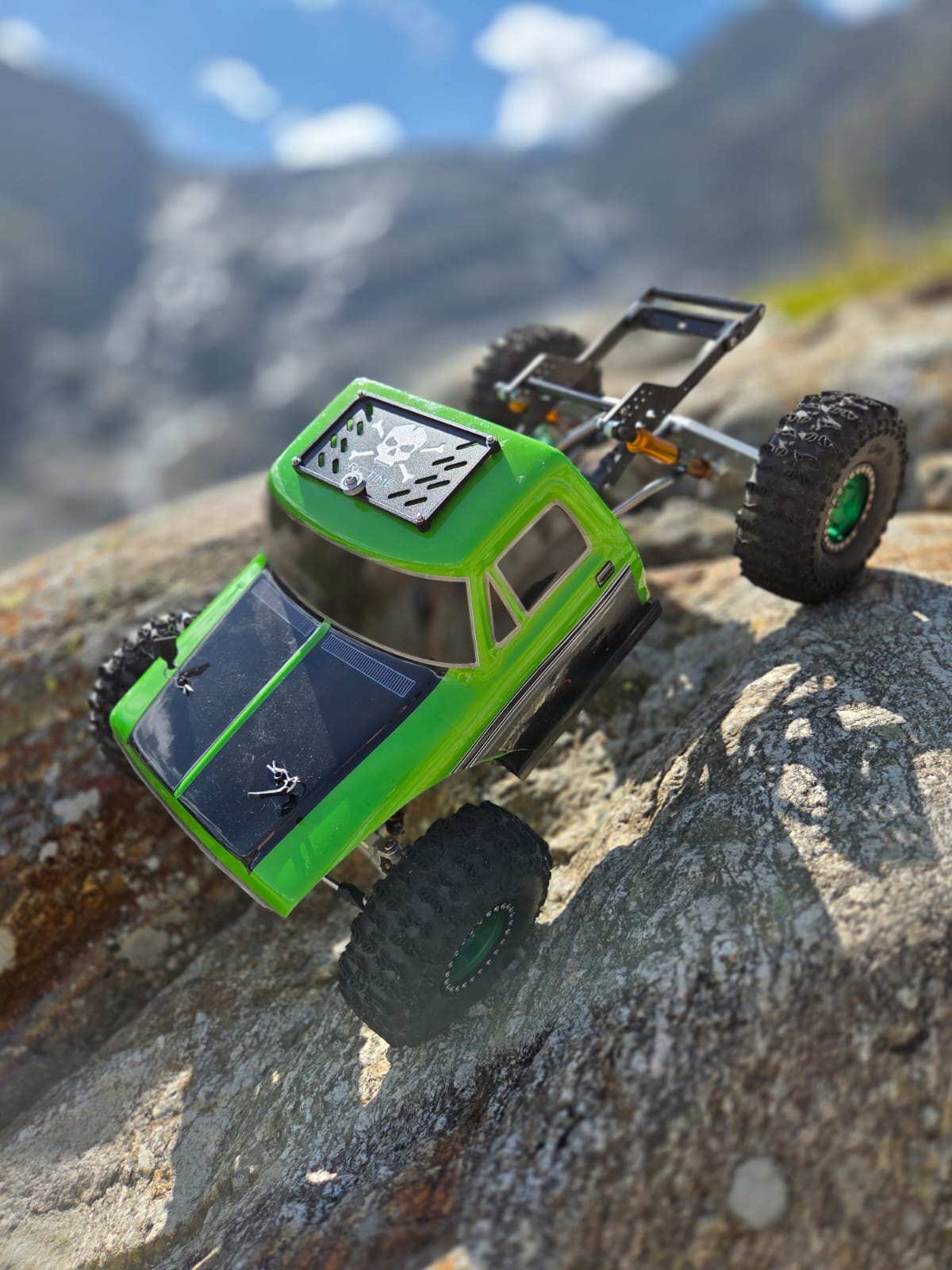 Marcels grüner RC-Crawler mit freiliegendem LCG-Chassis auf einem Felsen im Gebirge
